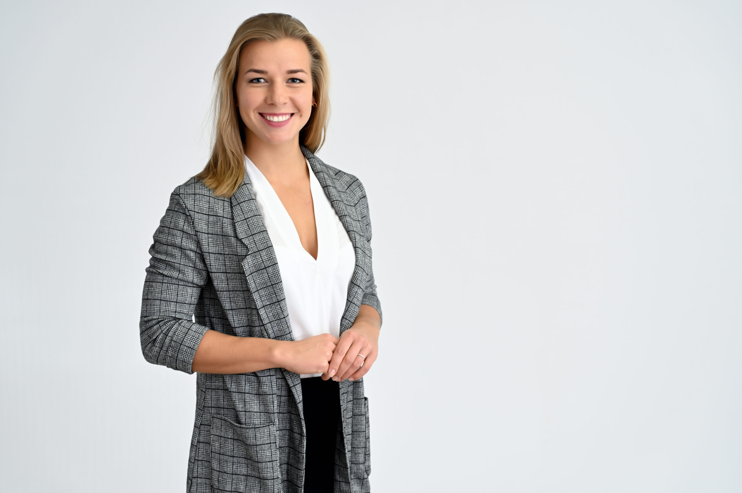 Close-up portrait of a cute caucasian blonde female student girl in a gray jacket on a white background. Wide smile, happiness. It is in different poses.